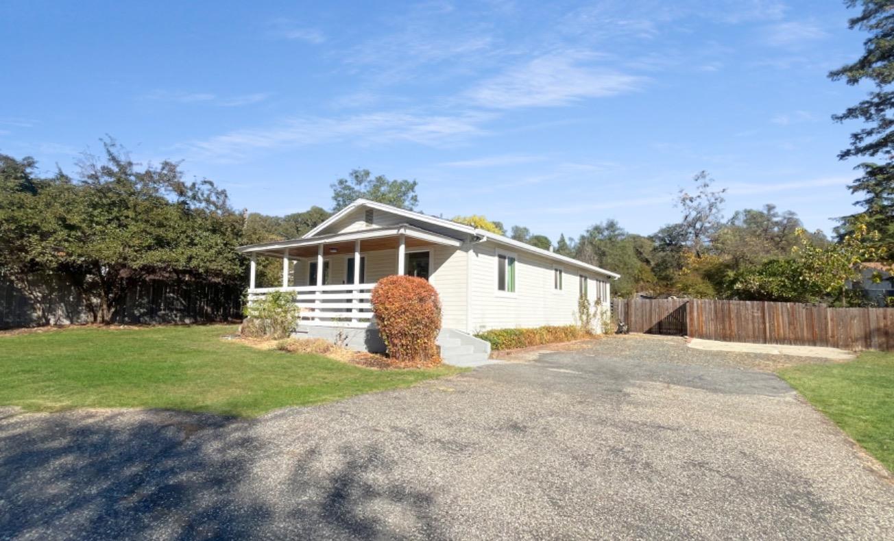 a front view of a house with a yard and trees