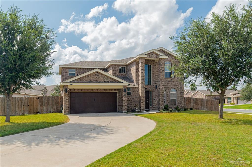 View of front of home with a garage and a front lawn