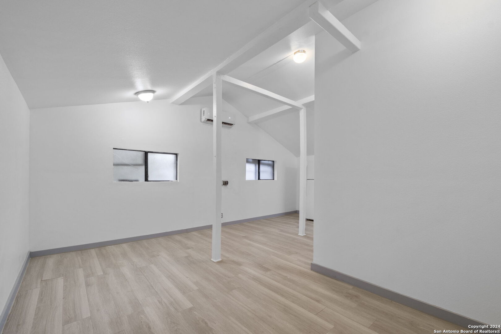 an empty room with wooden floor hallway and closet area