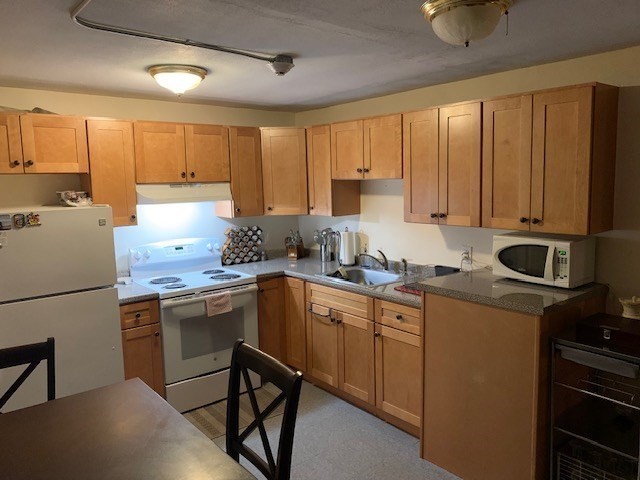 a kitchen with a sink appliances and cabinets