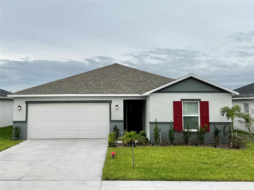 a front view of house with yard and garage