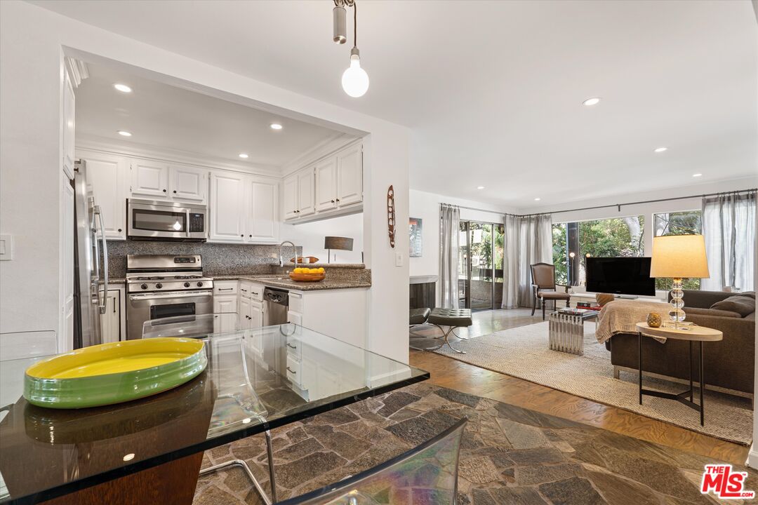 a living room with stainless steel appliances kitchen island granite countertop furniture and a kitchen view