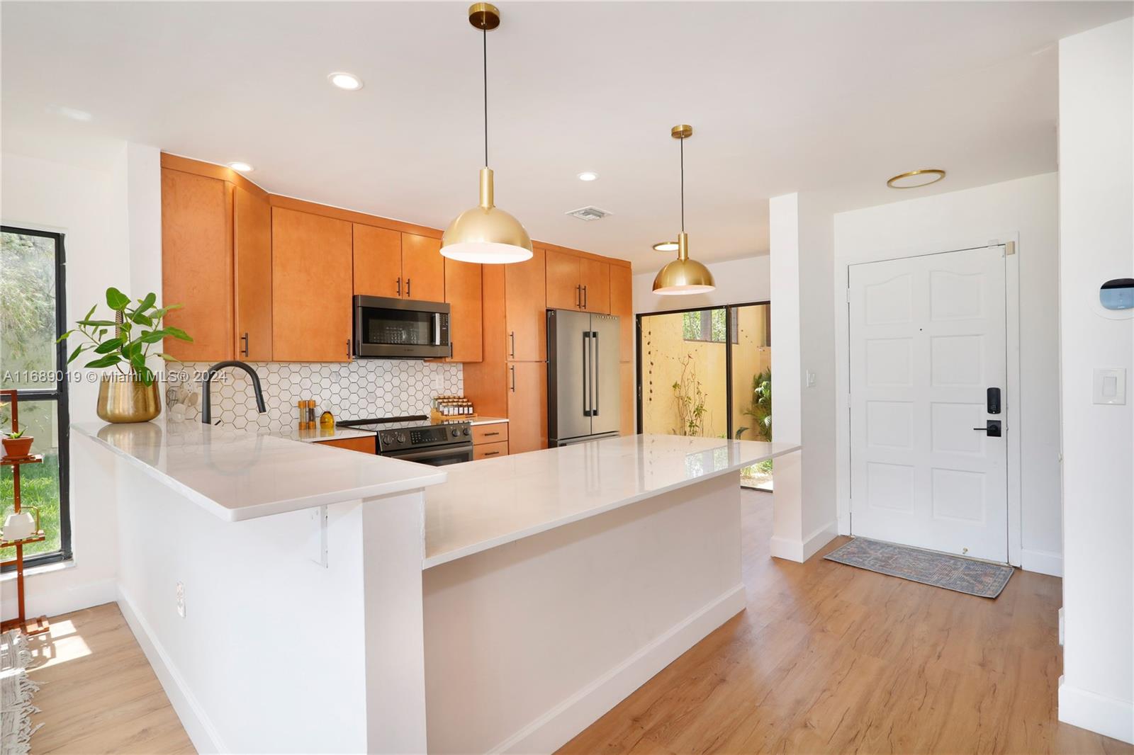 a kitchen with stainless steel appliances granite countertop a sink a stove and a wooden floor