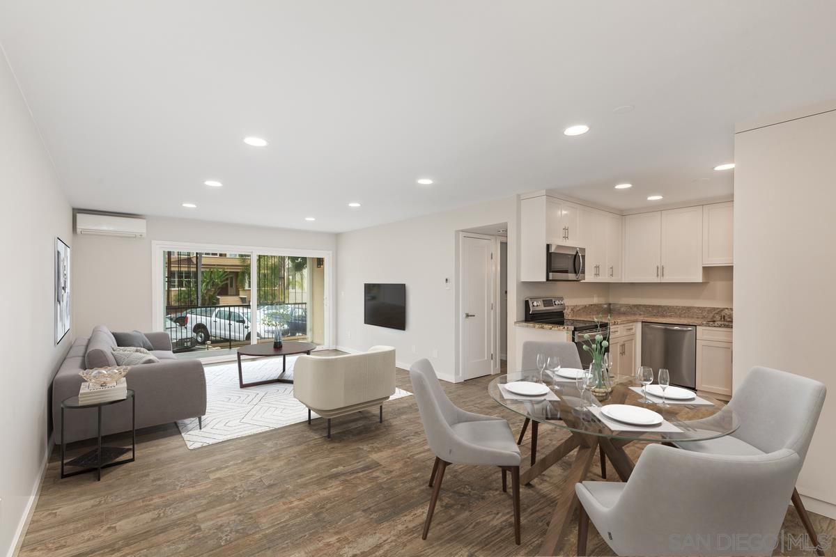 a living room with furniture kitchen view and a large window