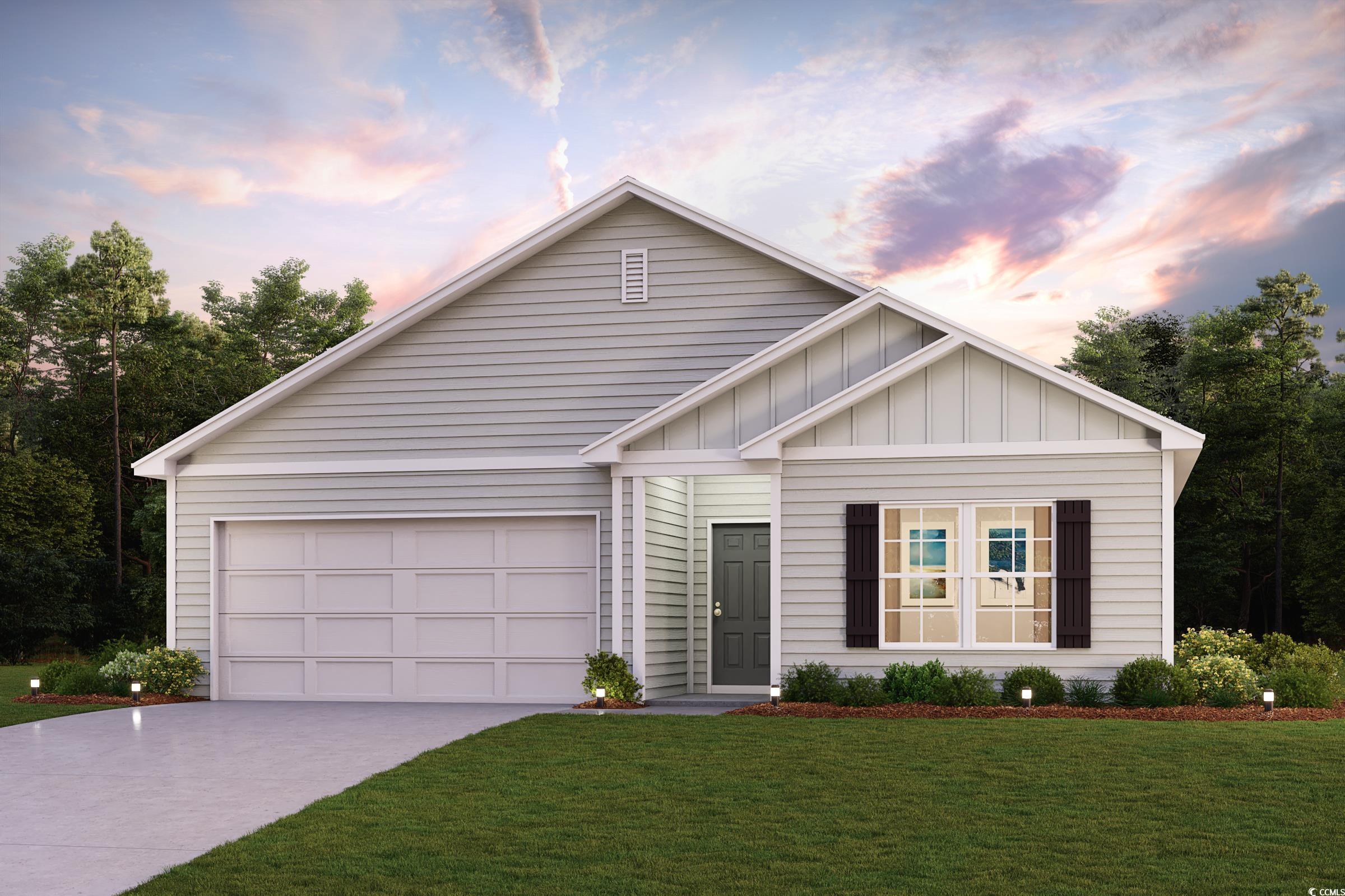 View of front facade featuring a yard and a garage