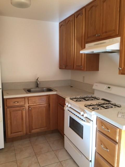 a kitchen with granite countertop a stove sink and cabinets