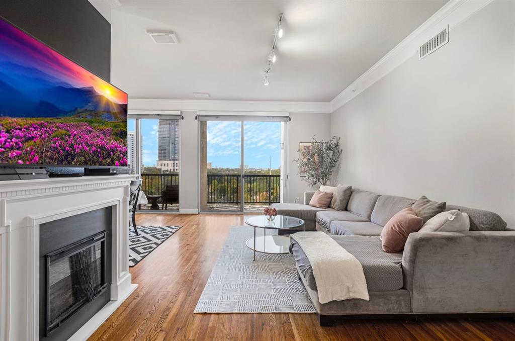 a living room with furniture a fireplace and a floor to ceiling window