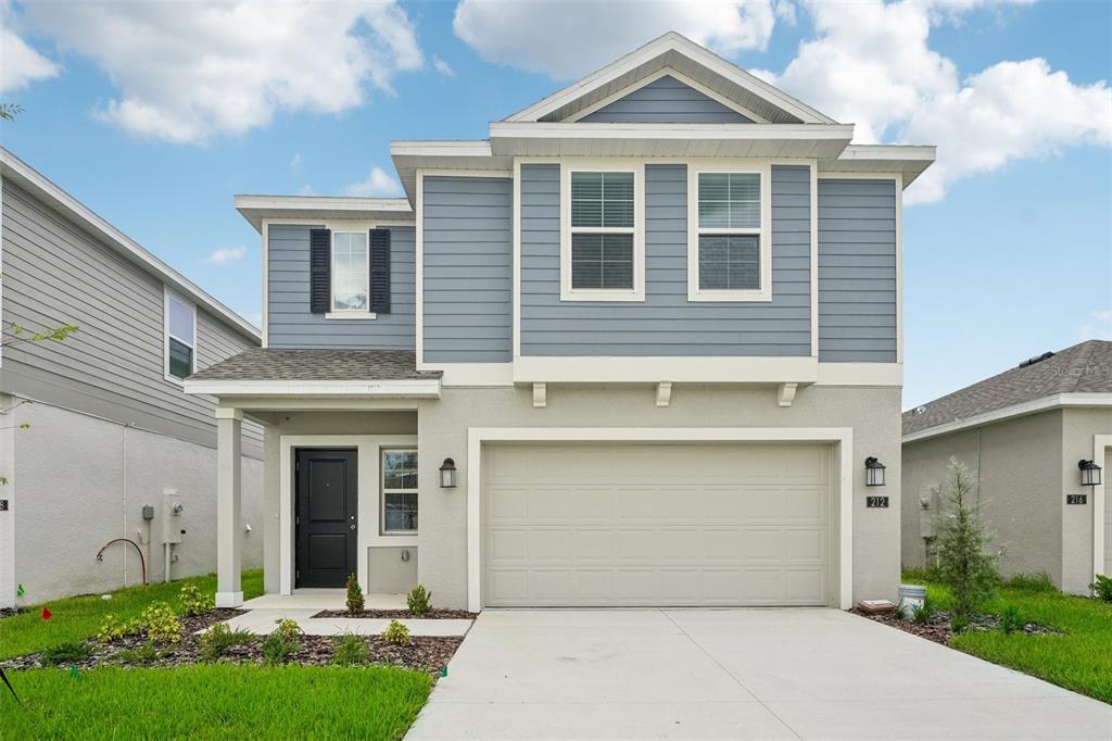 a front view of a house with a yard and garage