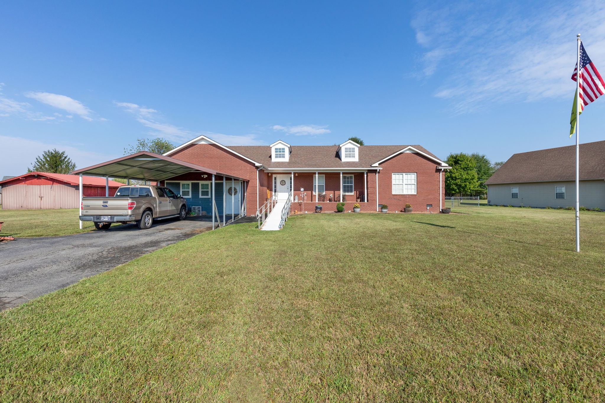 a front view of house with yard and car parked