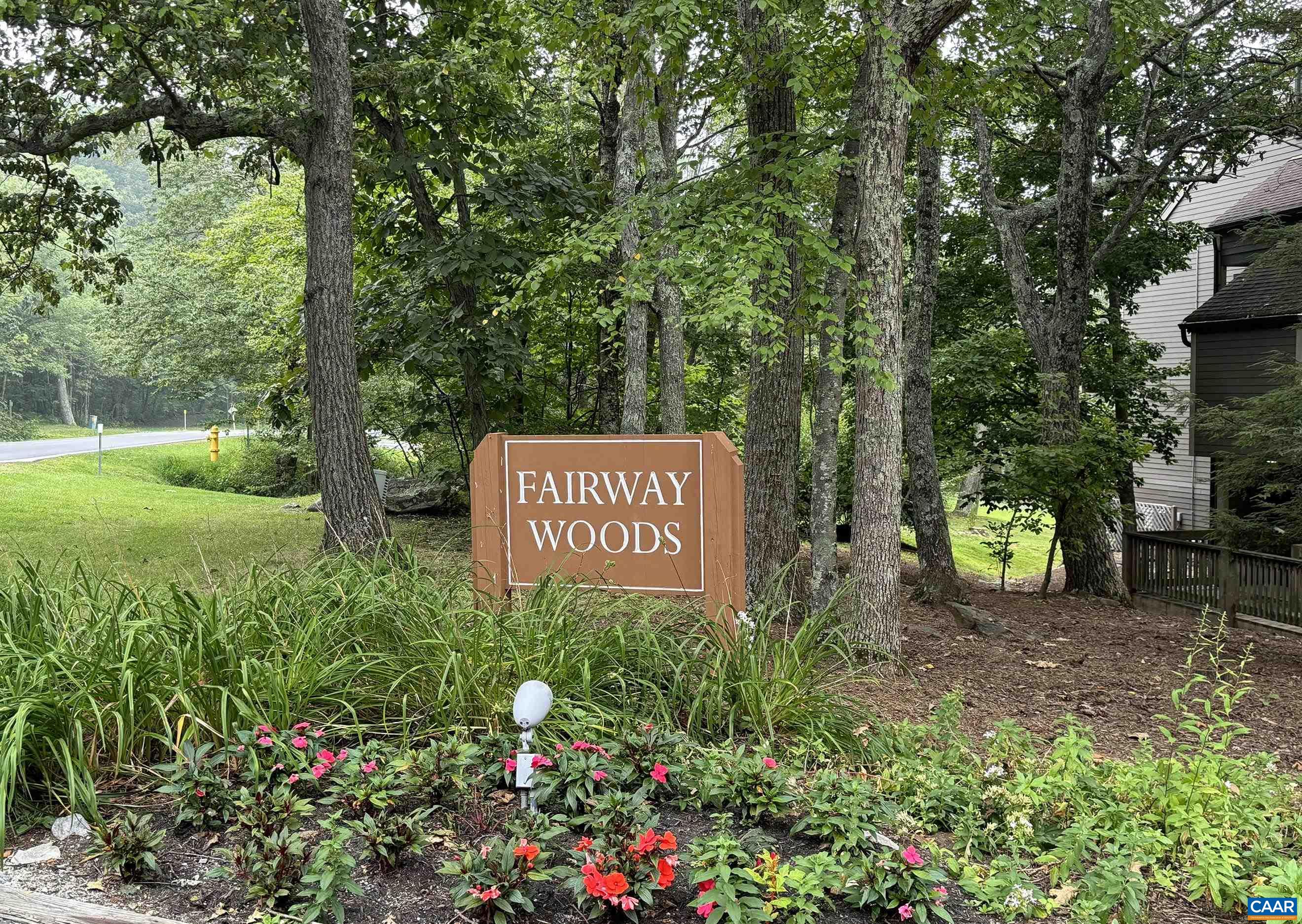 a sign that is sitting in a yard with potted plants