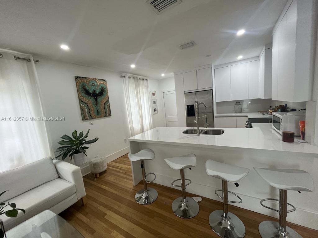 a kitchen with a table chairs refrigerator and microwave