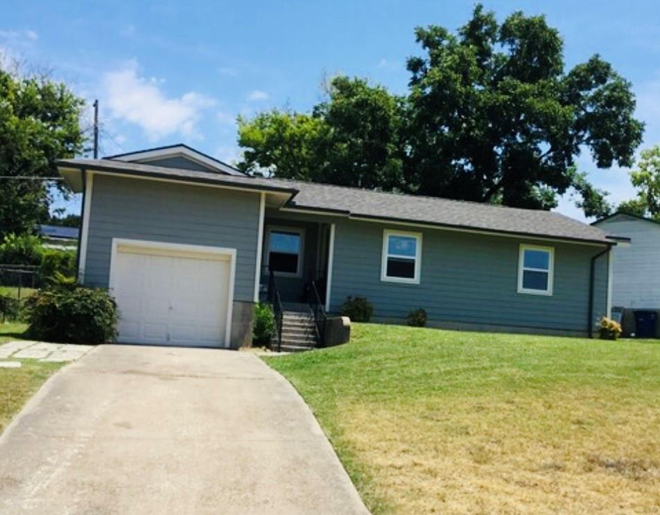 a front view of a house with yard and trees