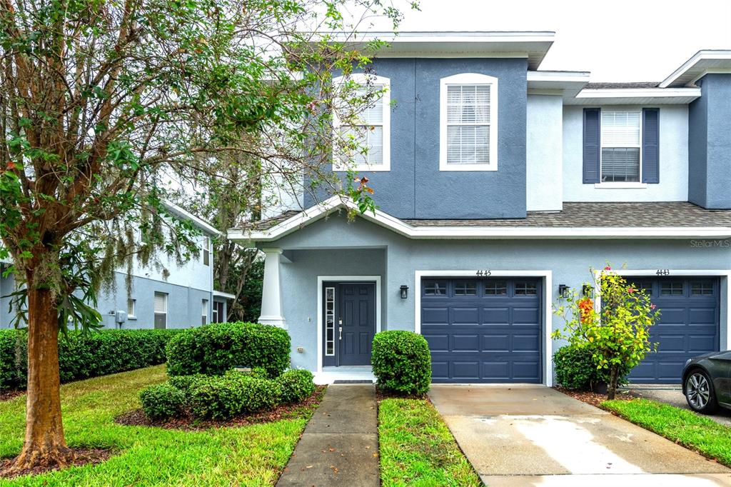 a front view of a house with a yard garage and outdoor seating