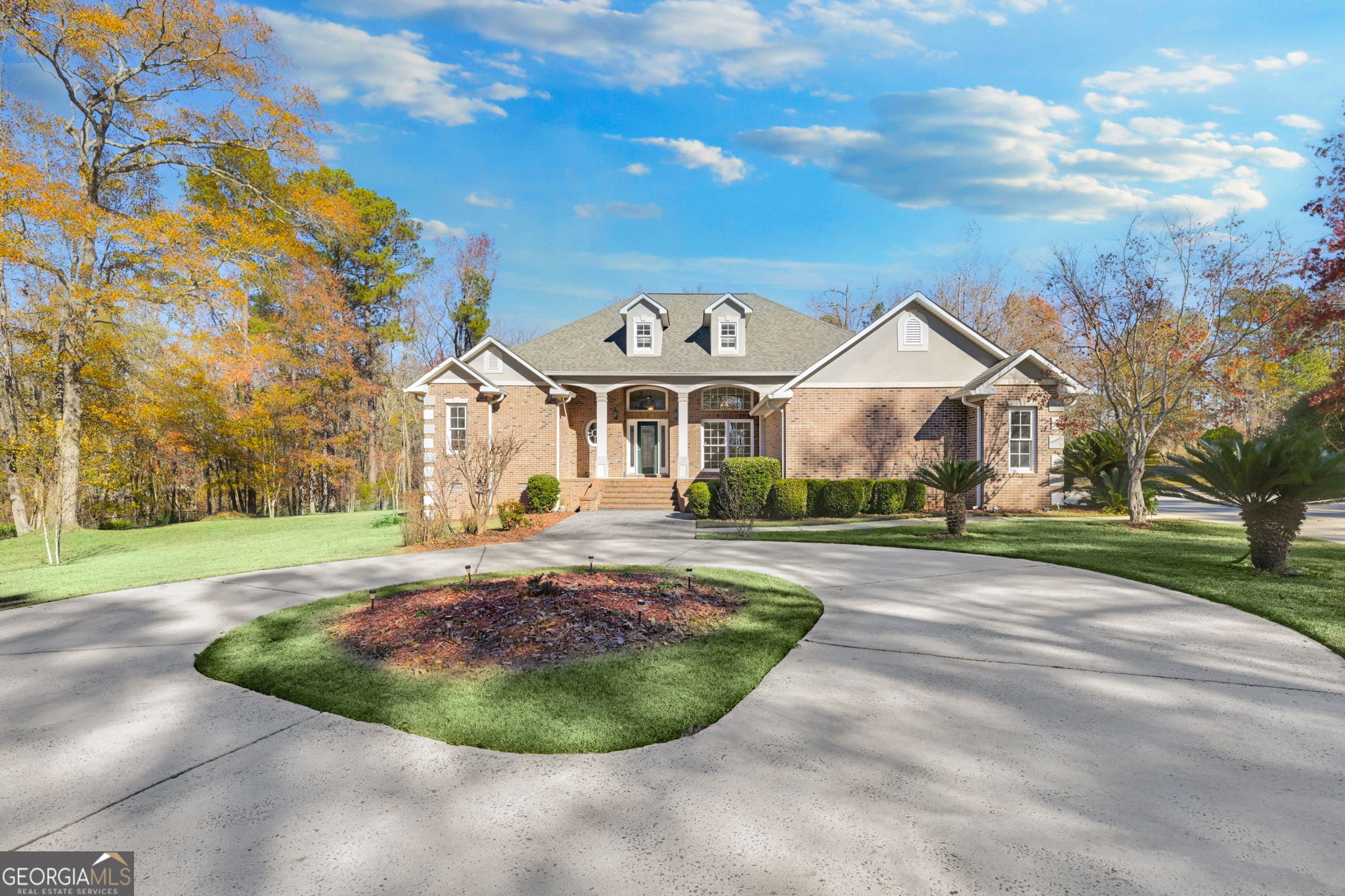 a view of a white house with a big yard and large trees