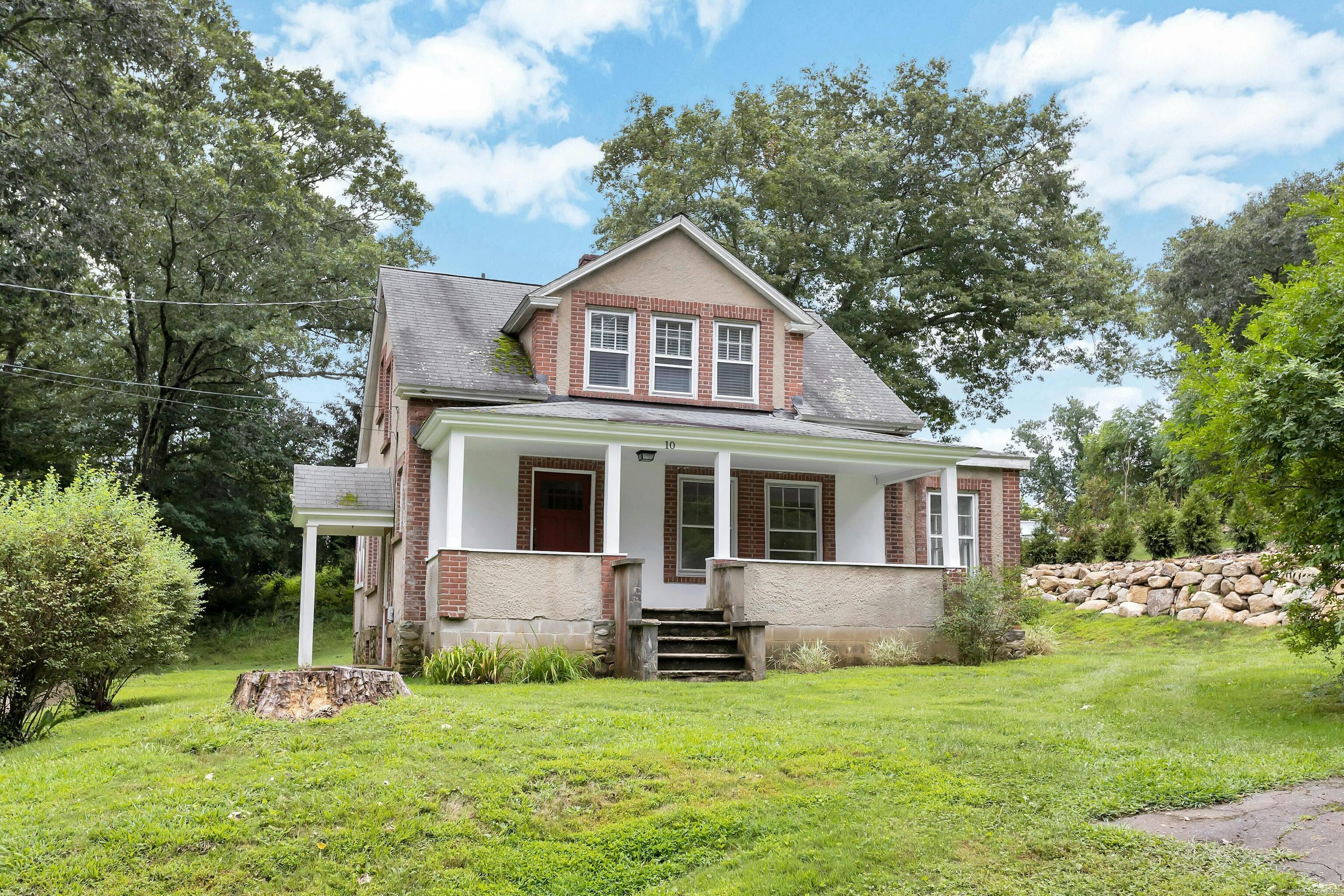 a front view of a house with a yard and trees