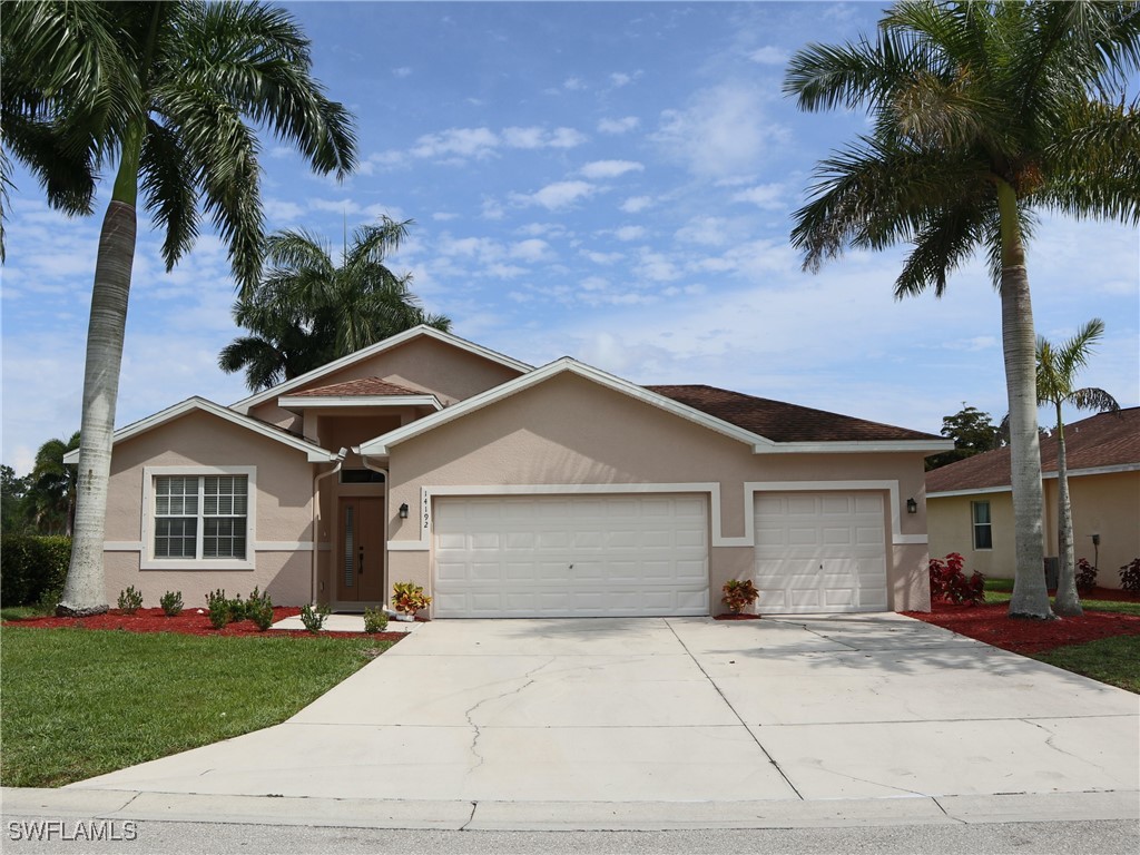 front view of a house with a yard and palm trees