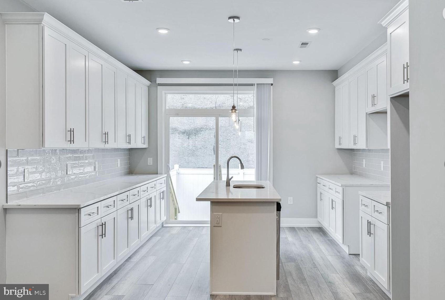 a kitchen with stainless steel appliances granite countertop a stove a sink and white cabinets