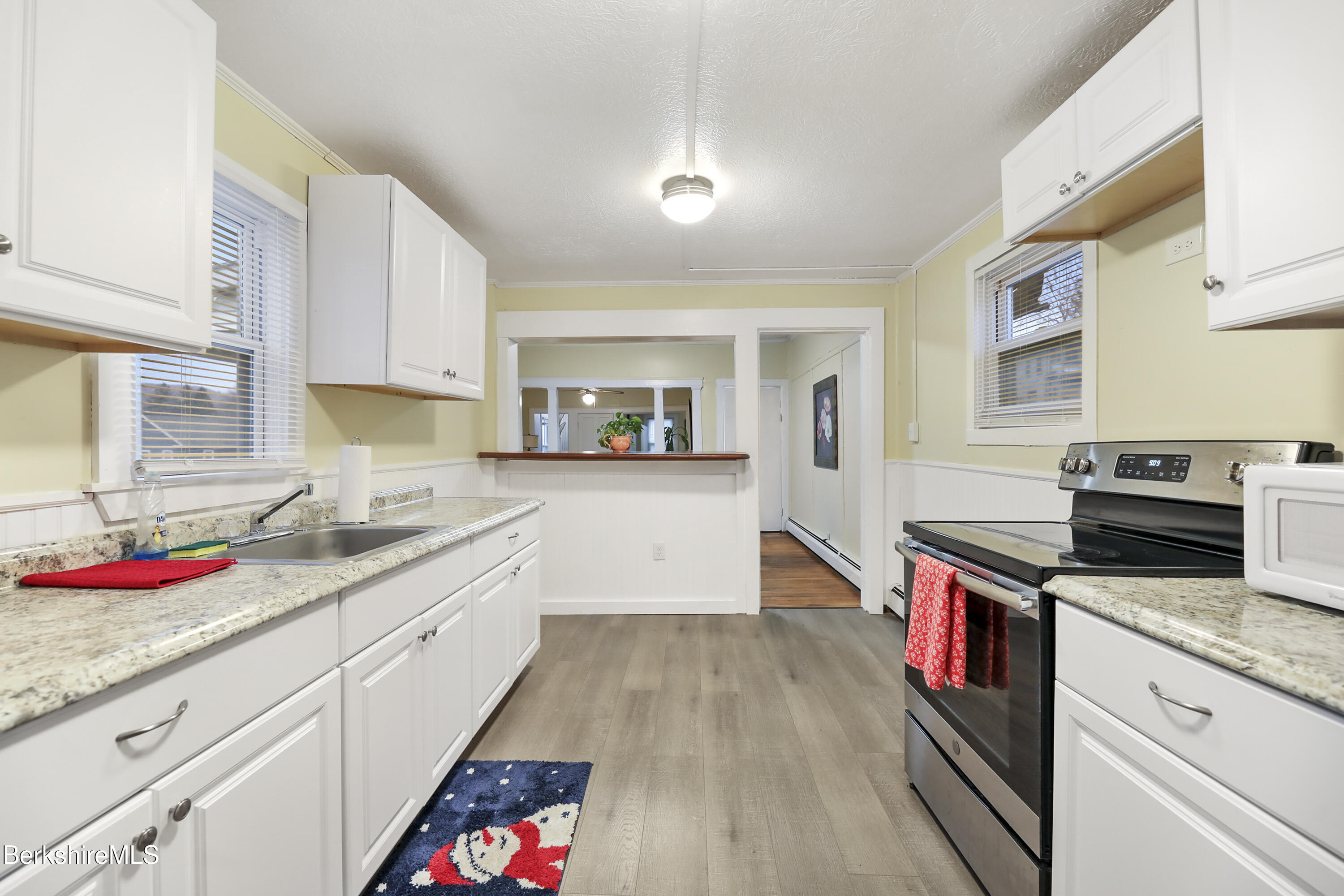 a kitchen with granite countertop stainless steel appliances sink stove and cabinets