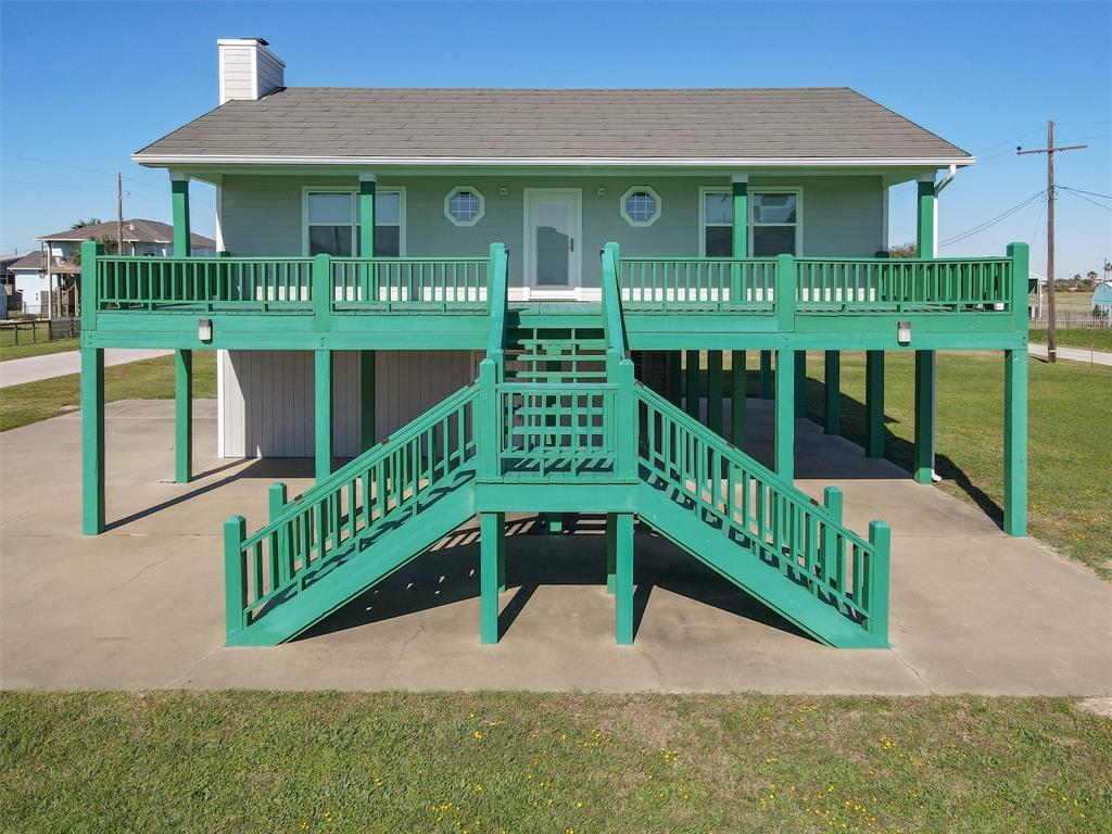 a view of a house with wooden deck and a yard