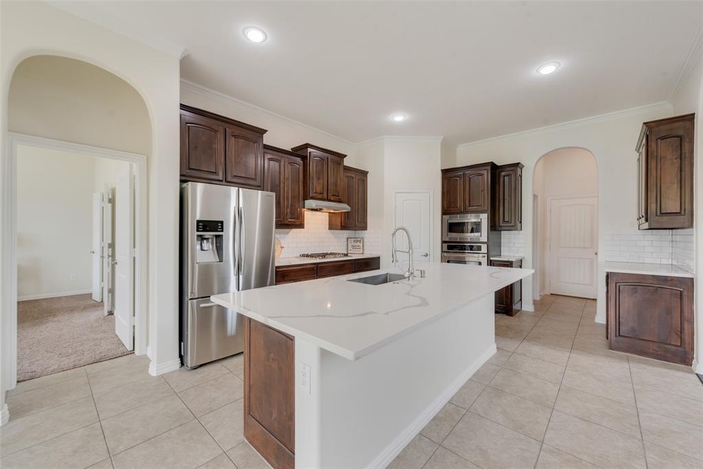 a large kitchen with stainless steel appliances a refrigerator and a stove top oven