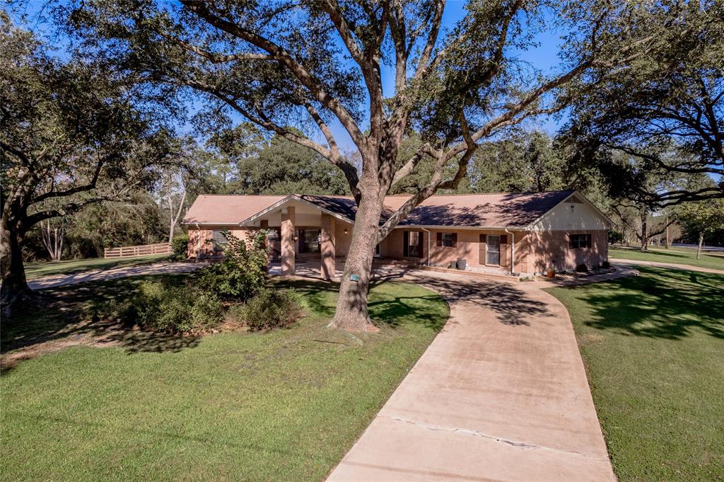 a front view of a house with a yard and trees