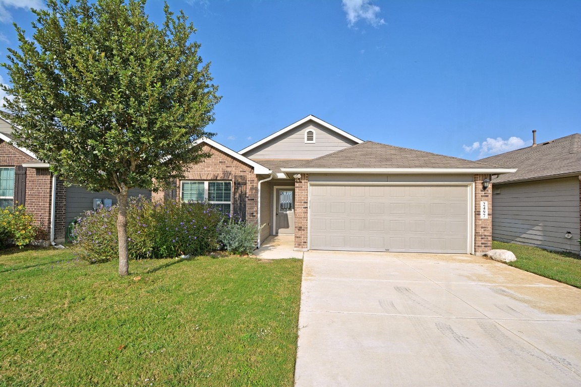 a front view of a house with a yard and garage