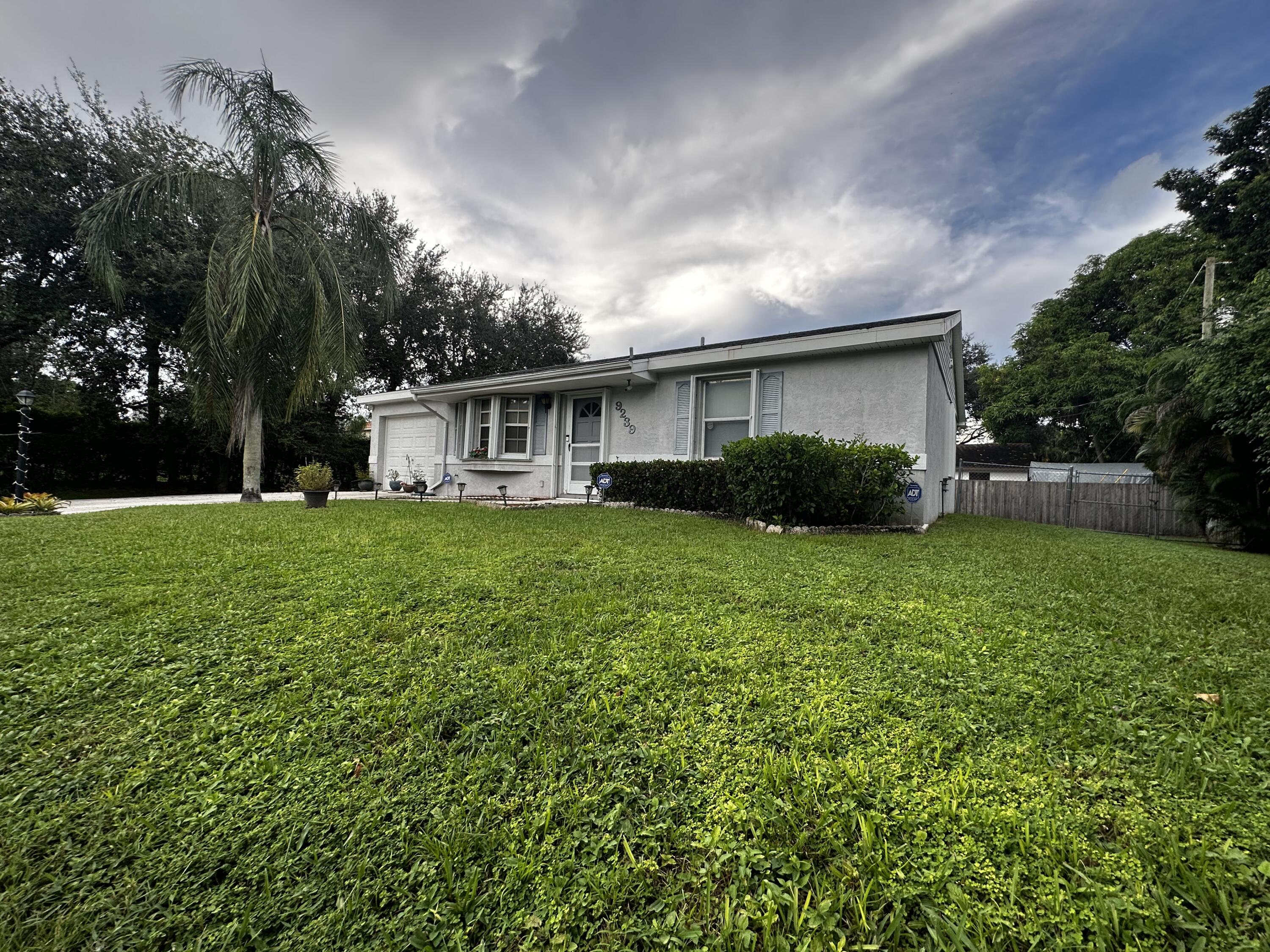 a view of house with yard and green space