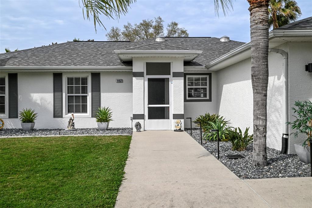 a front view of a house with a garden and plants