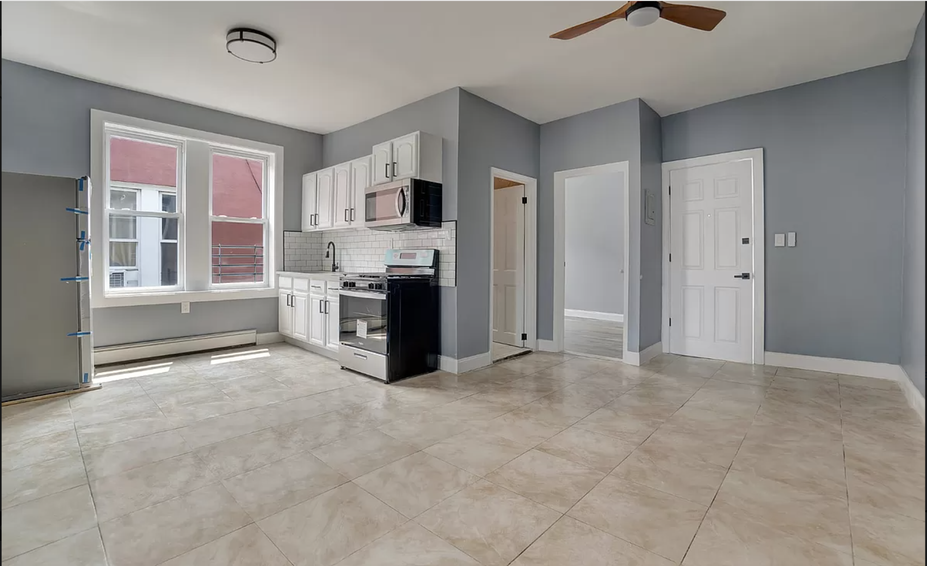 a view of kitchen with stainless steel appliances granite countertop a stove and cabinets