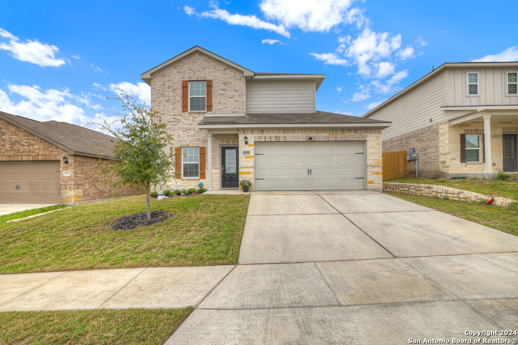 a front view of a house with a yard and garage