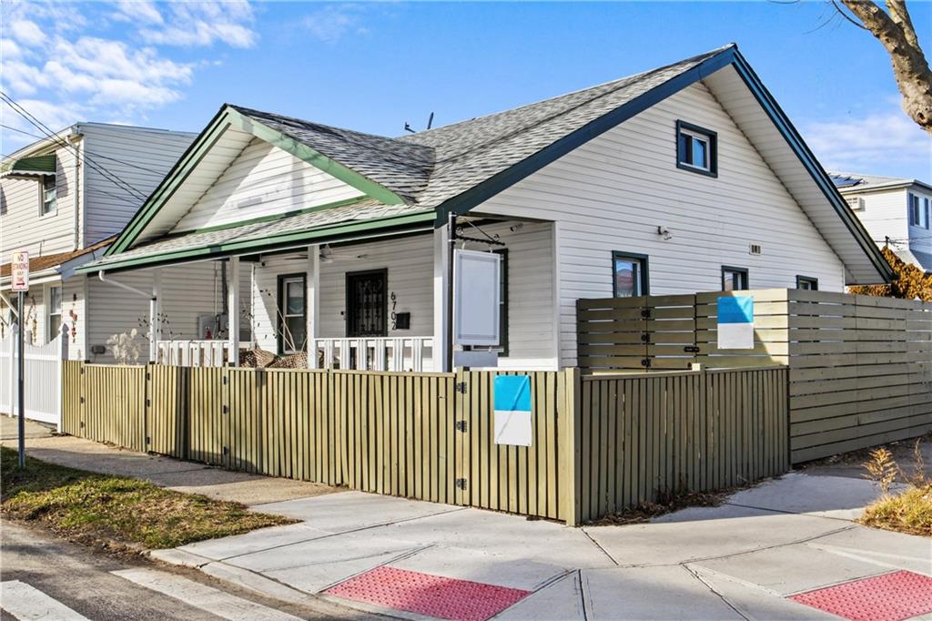 a view of a house with a small yard and wooden fence