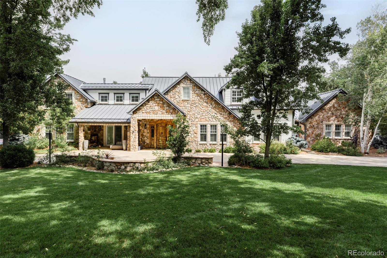 a front view of a house with a garden and trees