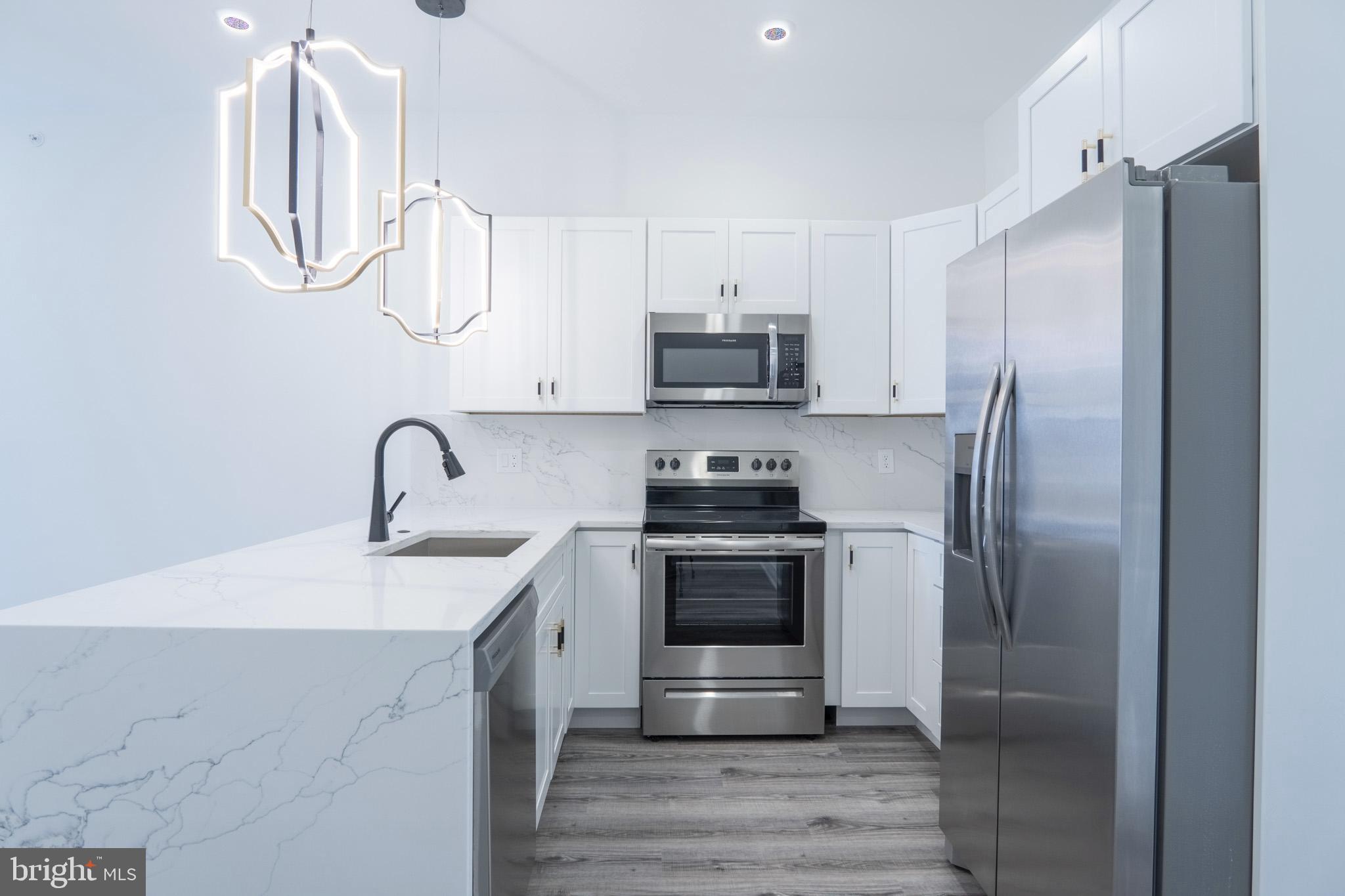 a kitchen with stainless steel appliances a refrigerator sink and cabinets