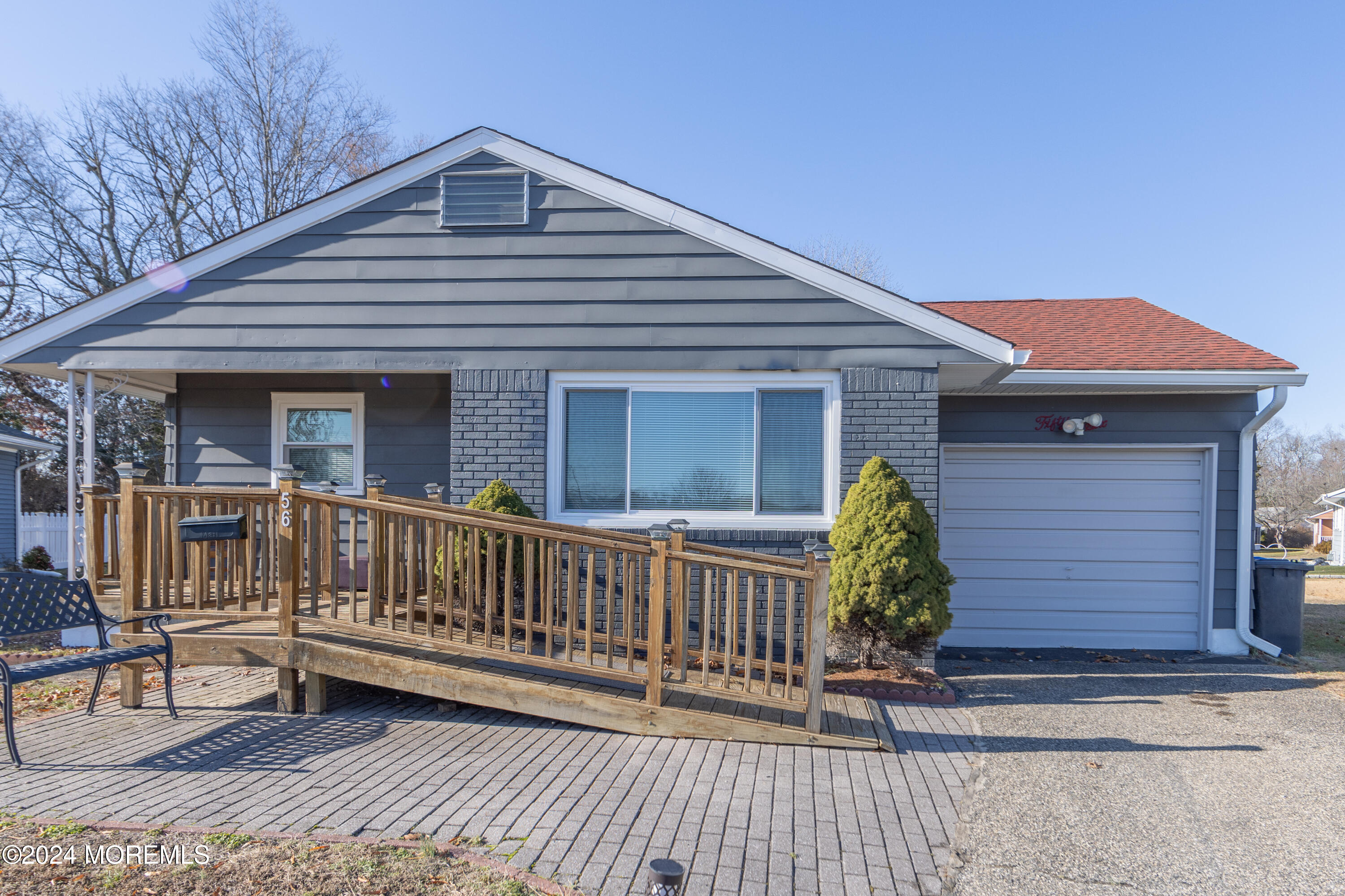 a view of a house with a small yard and wooden floor and fence