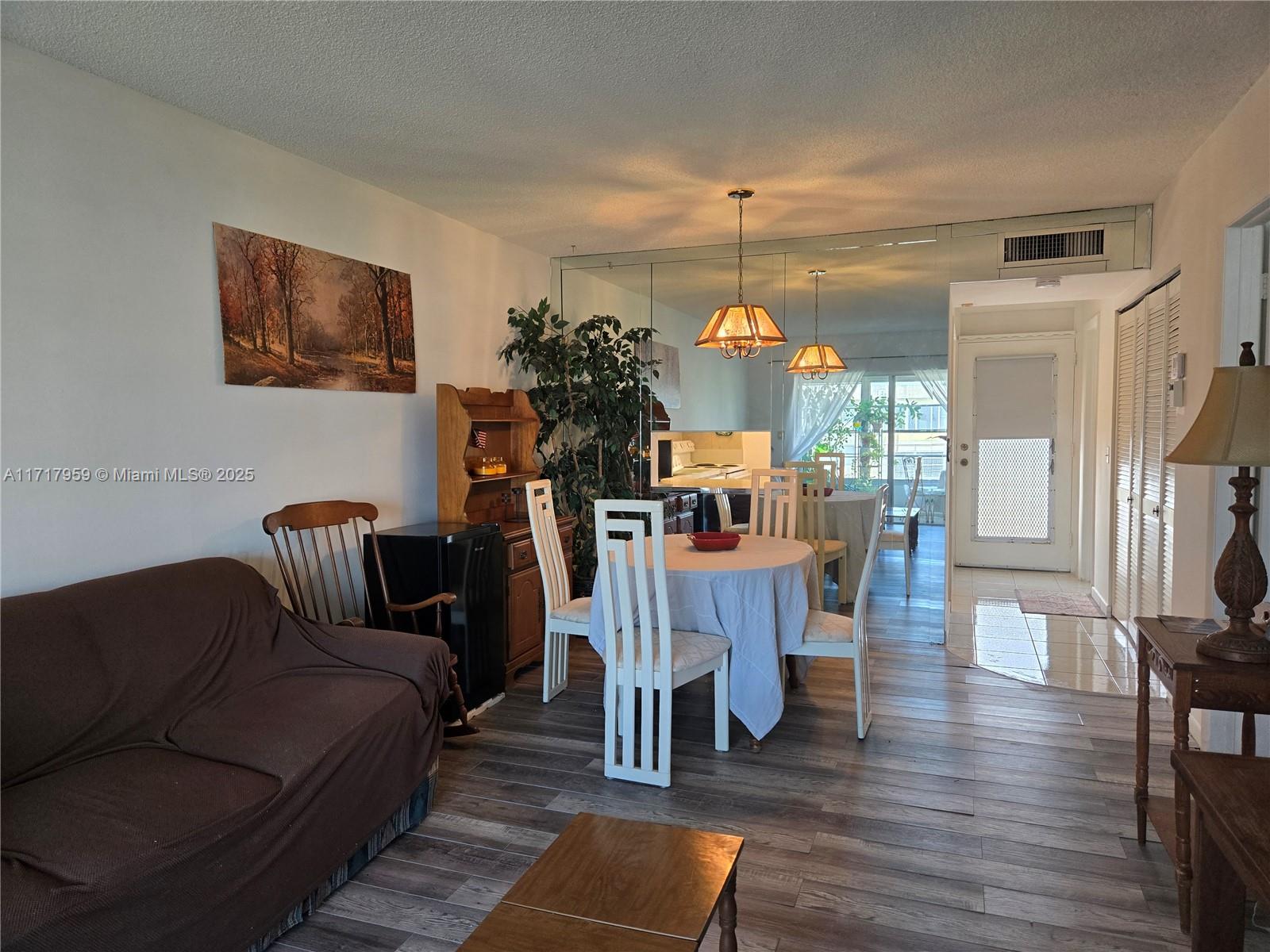 a view of a livingroom with furniture a dinning room and wooden floor