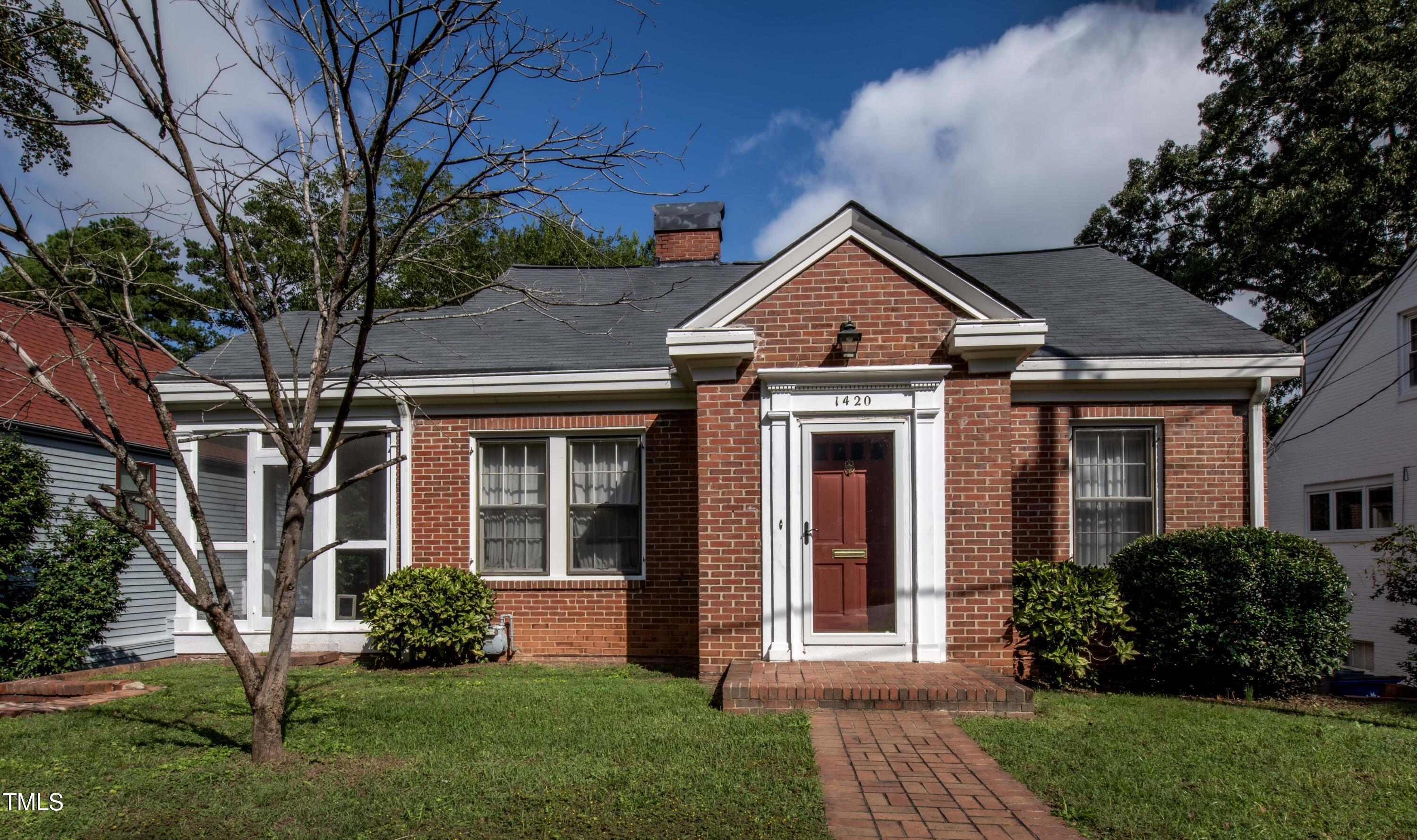 a front view of a house with a yard and trees