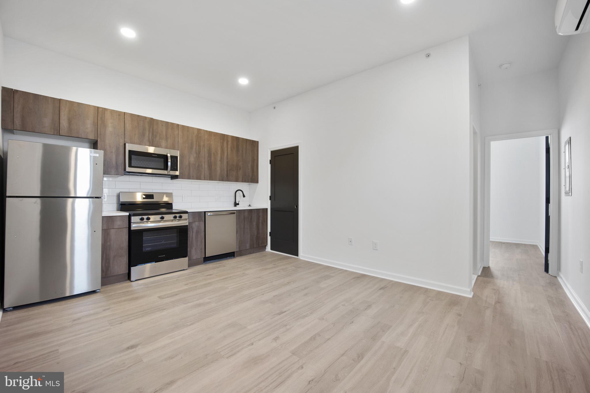 a kitchen with stainless steel appliances a refrigerator and a stove top oven