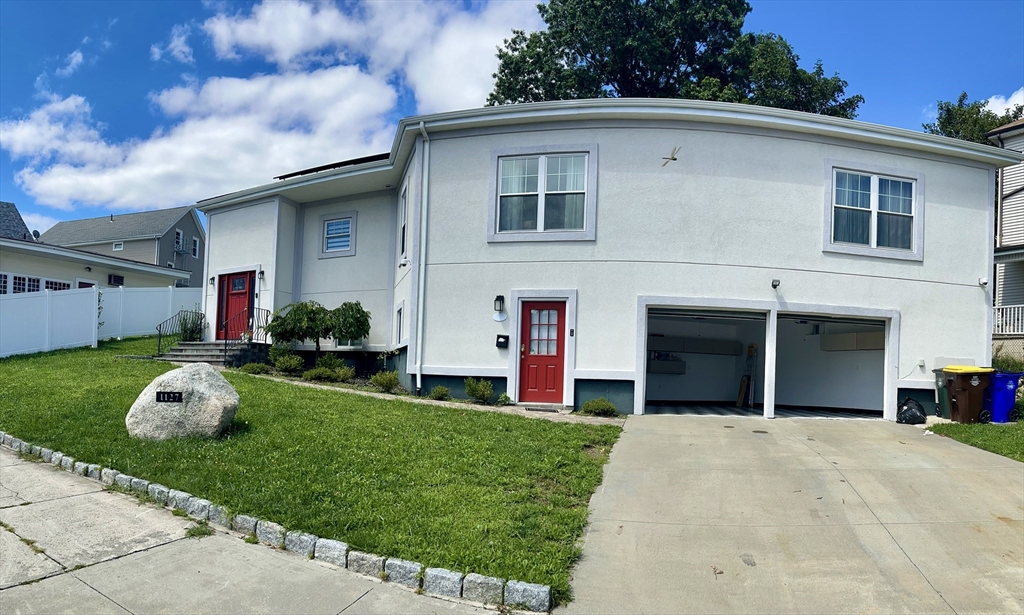 a front view of a house with a yard and garage