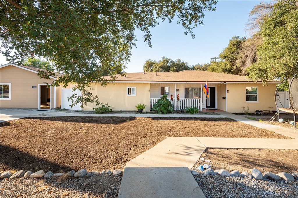 a front view of house with yard and trees around