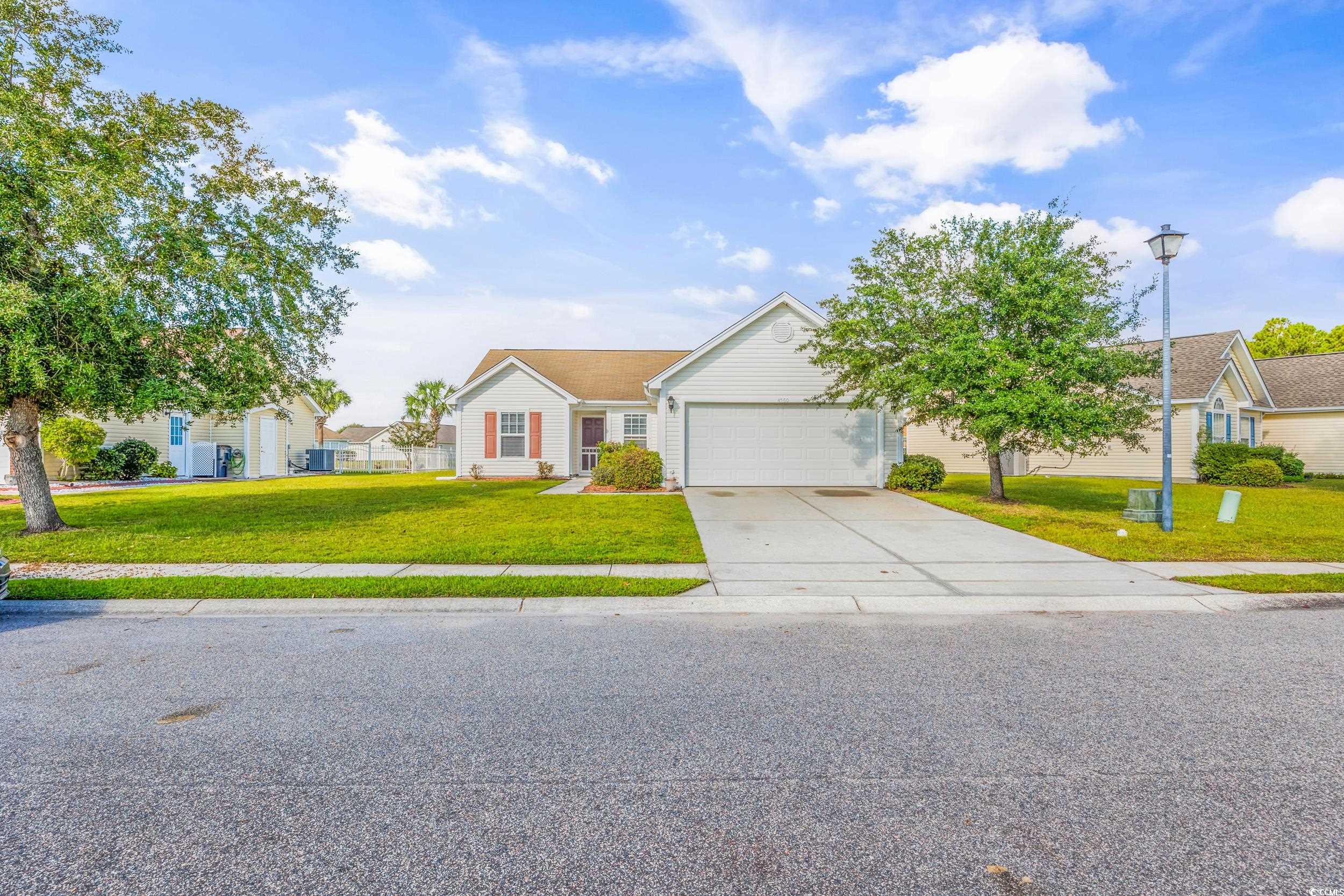 Ranch-style house featuring a front yard and a gar