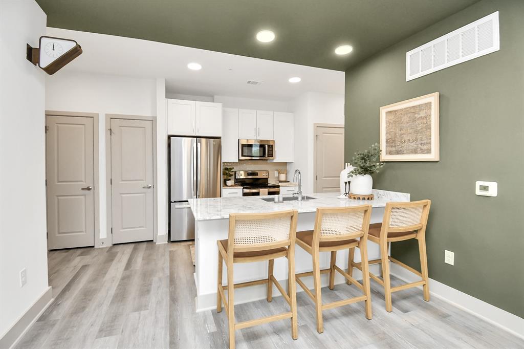 a kitchen with stainless steel appliances kitchen island granite countertop a refrigerator and a stove top oven