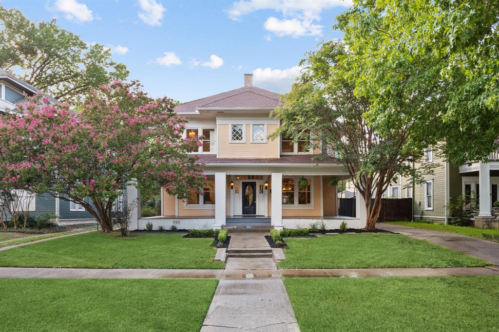 a front view of a house with a yard and an trees