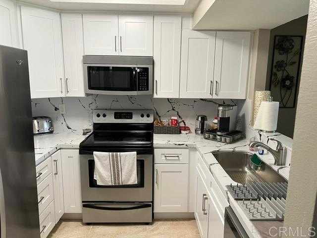 a kitchen with a sink a stove and cabinets