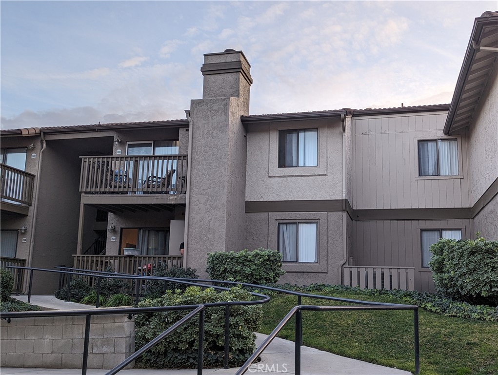 a front view of a house with balcony and garden