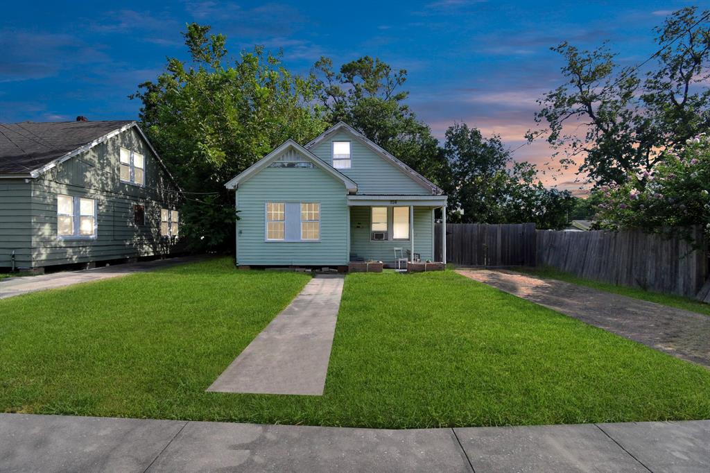 a front view of a house with a garden and yard