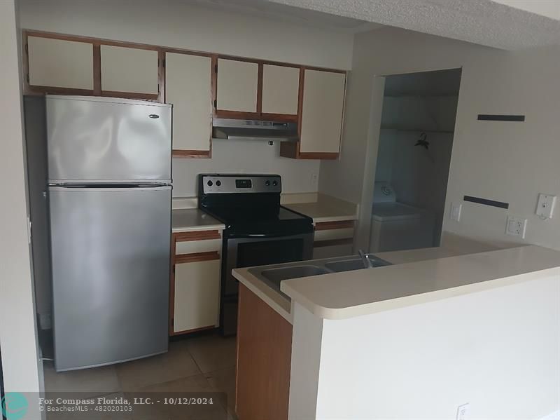 a white refrigerator freezer and a stove sitting inside of a kitchen