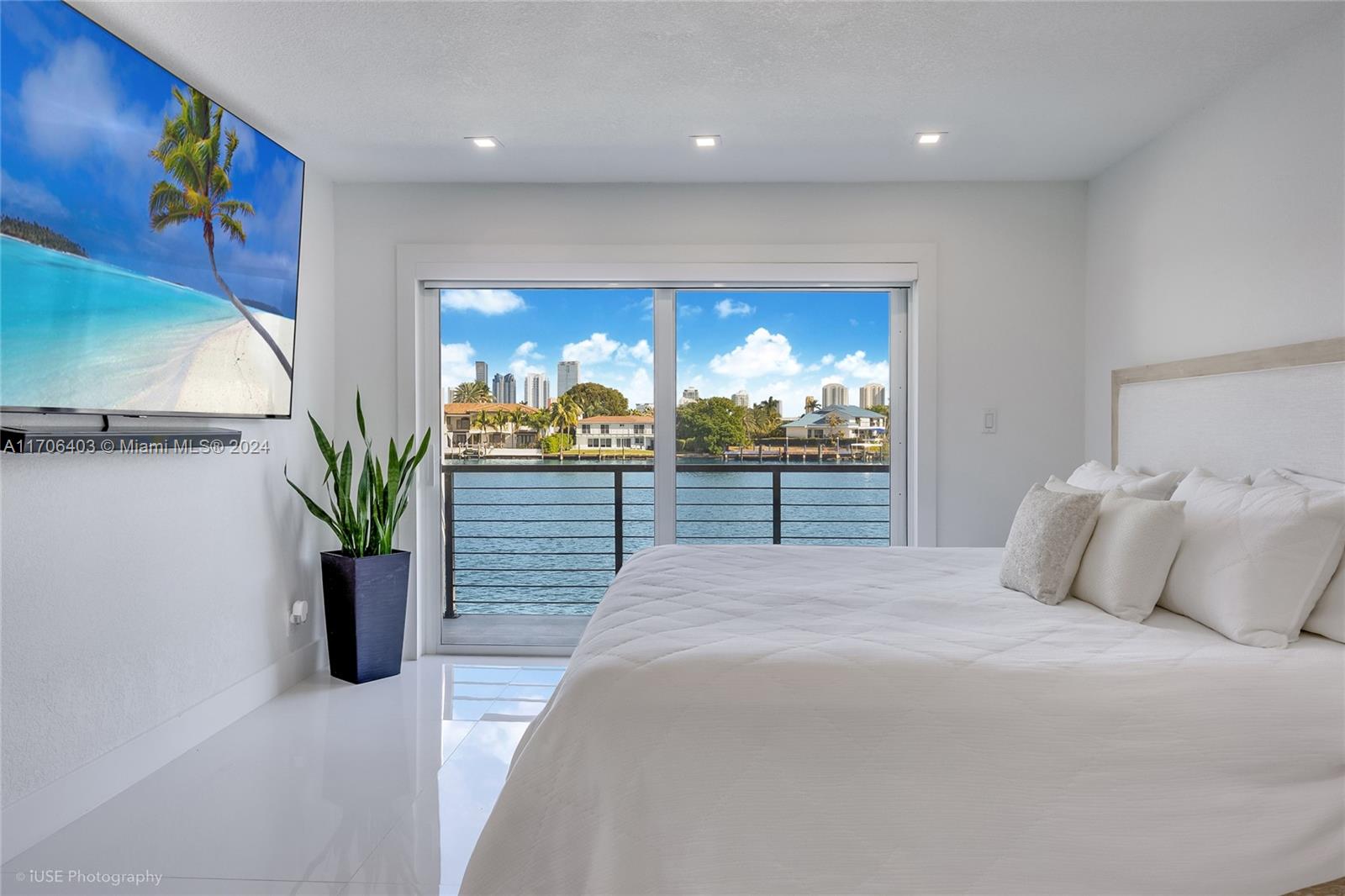 a bedroom with a large bed and a potted plant