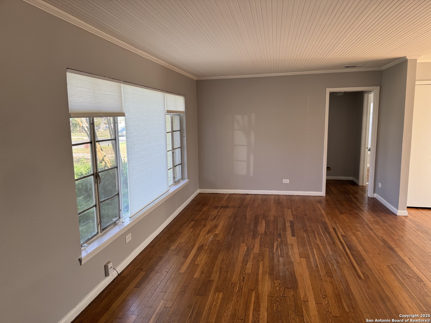 wooden floor in an empty room with a window