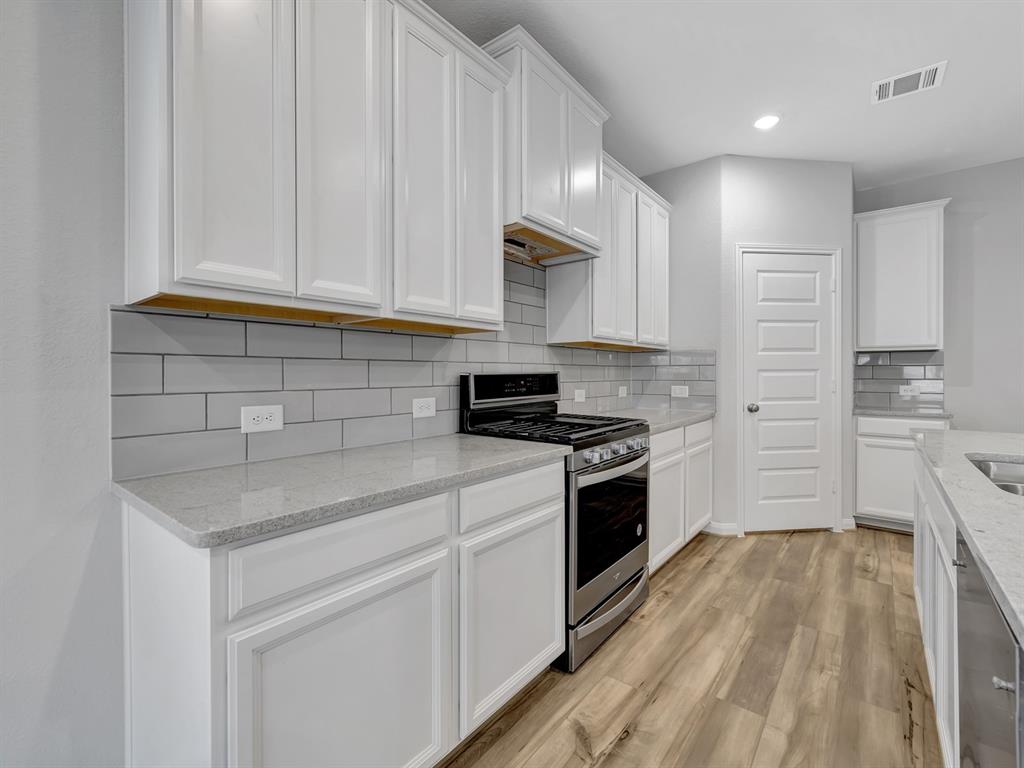 a kitchen with a sink stove and cabinets