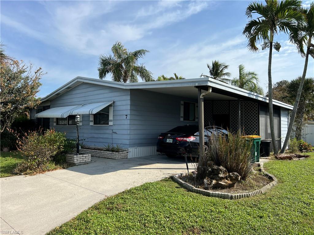 View of home's exterior with a yard and a carport